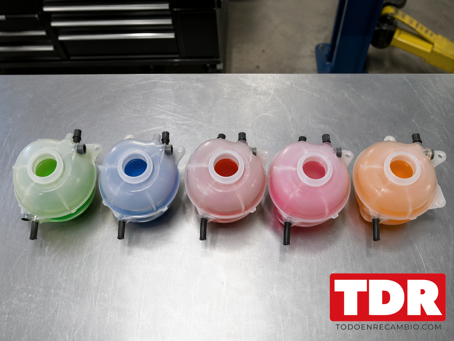 Cinco depositos con liquido refrigerante en distintos colores: azul G11, rojo G12, violeta G13, rosa y naranja