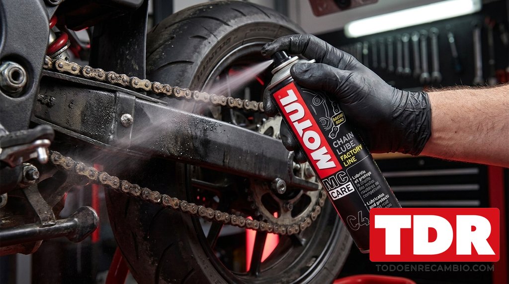 Aplicando lubricante Motul en la cadena de una moto en el taller