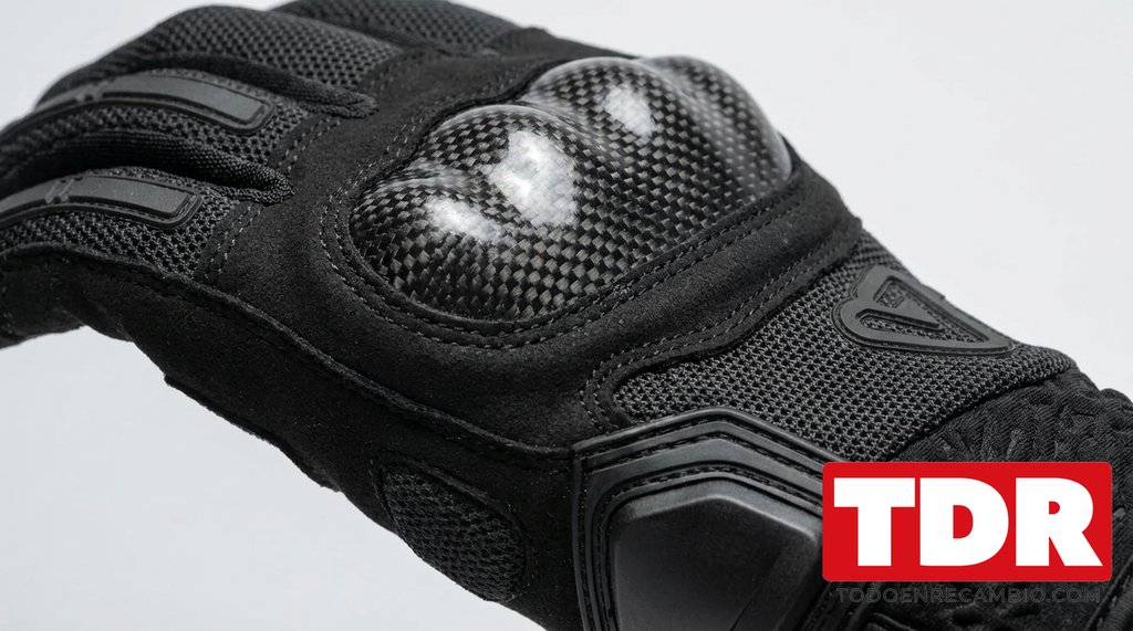 Detalle del protector de carbono en los nudillos y el refuerzo de la palma de un guante de moto