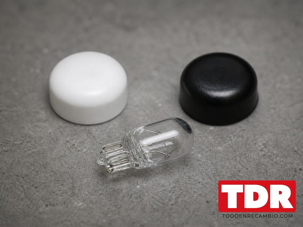 Lampara de luz de matricula tipo cuna junto a un capuchon de tornillo blanco y otro negro