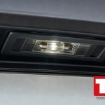 Luz de matricula encendida en el porton trasero de un coche sobre la placa