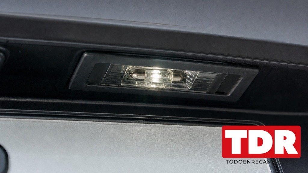 Luz de matricula encendida en el porton trasero de un coche sobre la placa