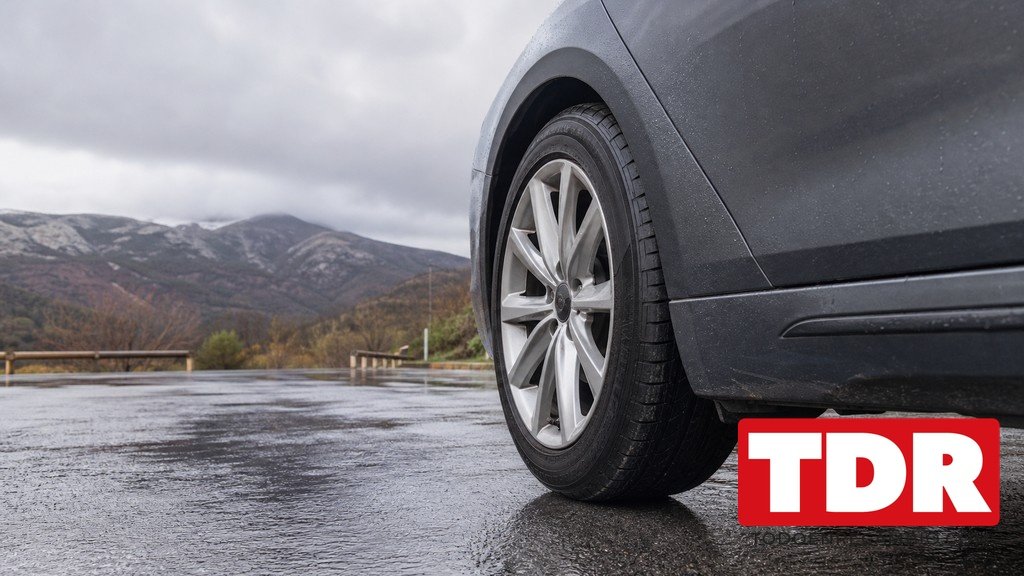 Neumatico de coche en carretera invernal con nieve al borde de la via