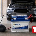 Mantenedor de bateria conectado a la bateria de un coche en un garaje